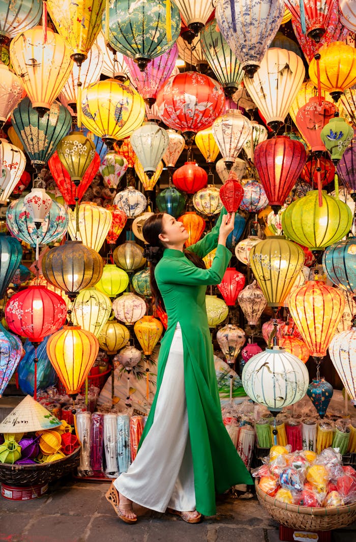 A woman in traditional áo dài amidst vivid lanterns in Hội An, capturing Vietnamese culture.