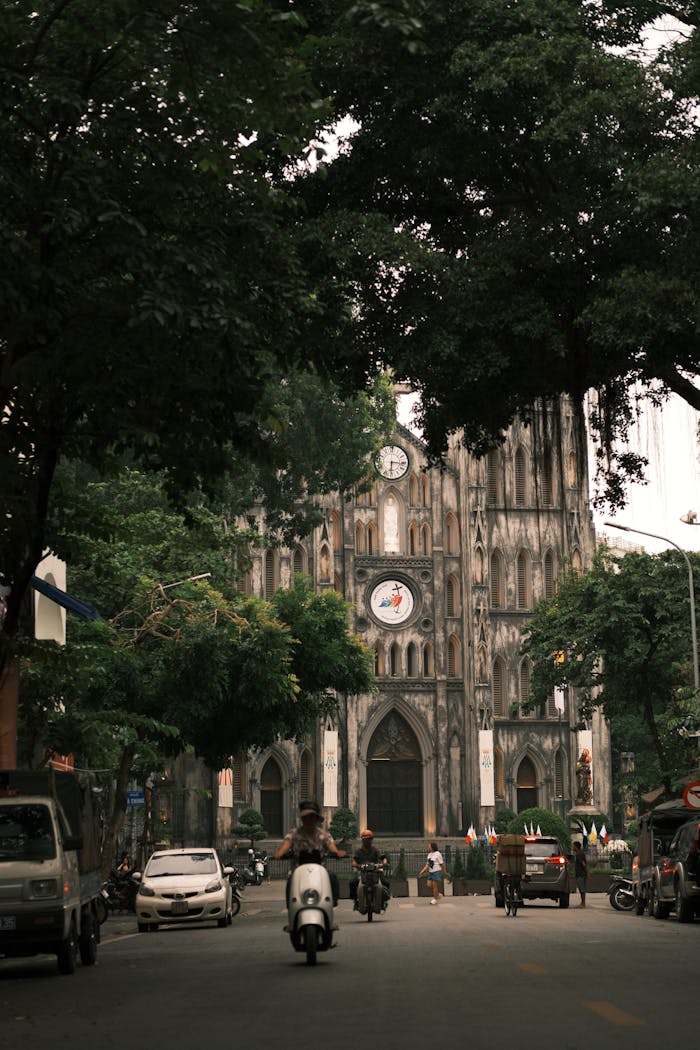 View of St. Joseph's Cathedral in Hanoi with bustling street life and lush surroundings.
