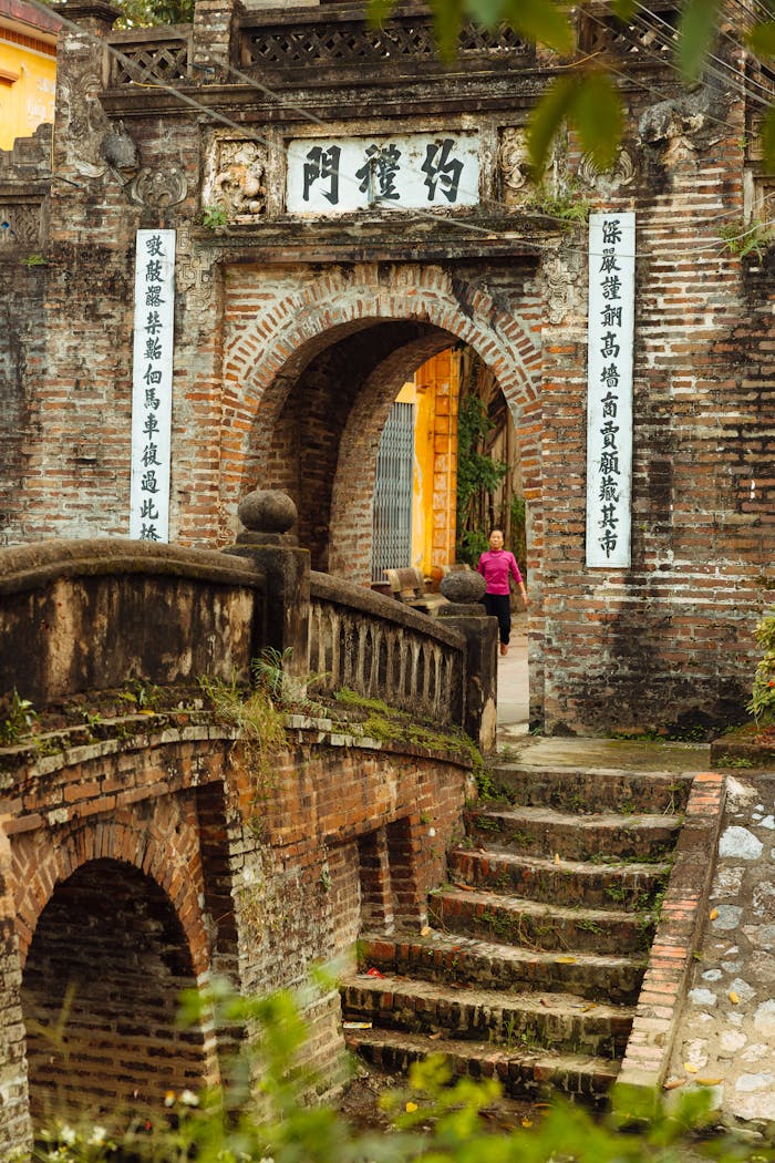 Historic Vietnamese gate and brick bridge capturing traditional architecture and cultural heritage.